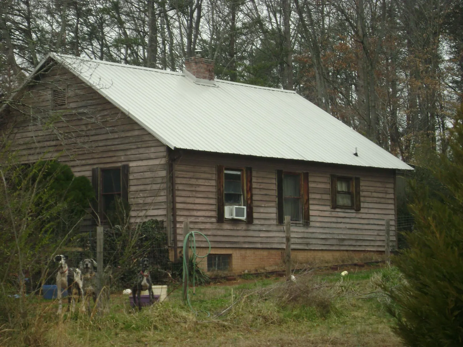White metal roof on an old wood sided farmhouse, from a Metal Roof Installation job in Gould